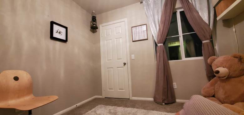 Empty nursery before painting, featuring plain beige walls ready for a transformation.